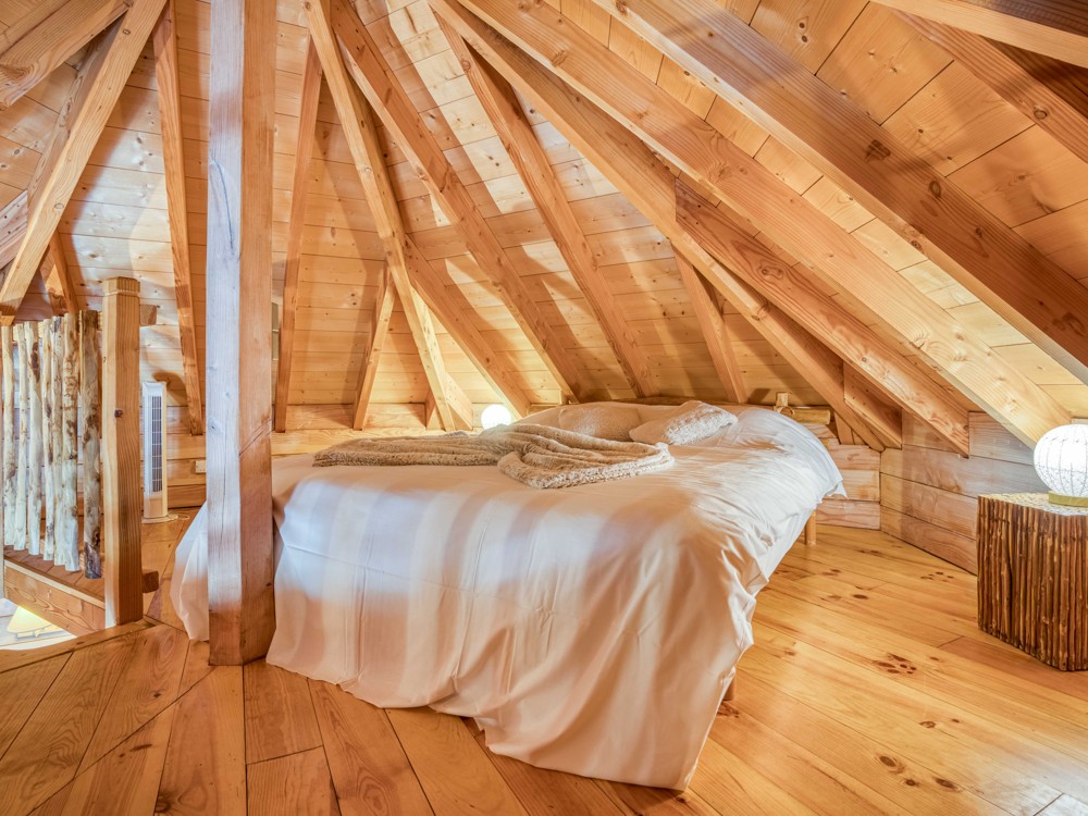 Le lit double sur la mezzanie de la cabane Sarlat